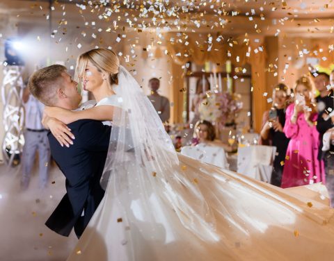 bride-couple-waving-while-dacning-with-confetti.jpg